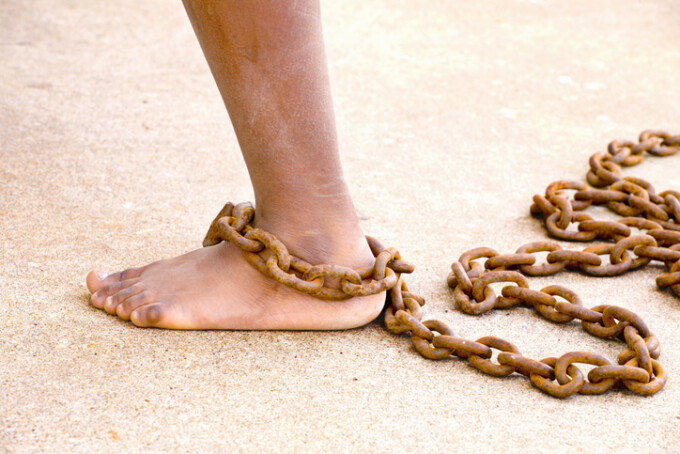 A foot bound in chains by the ankle.